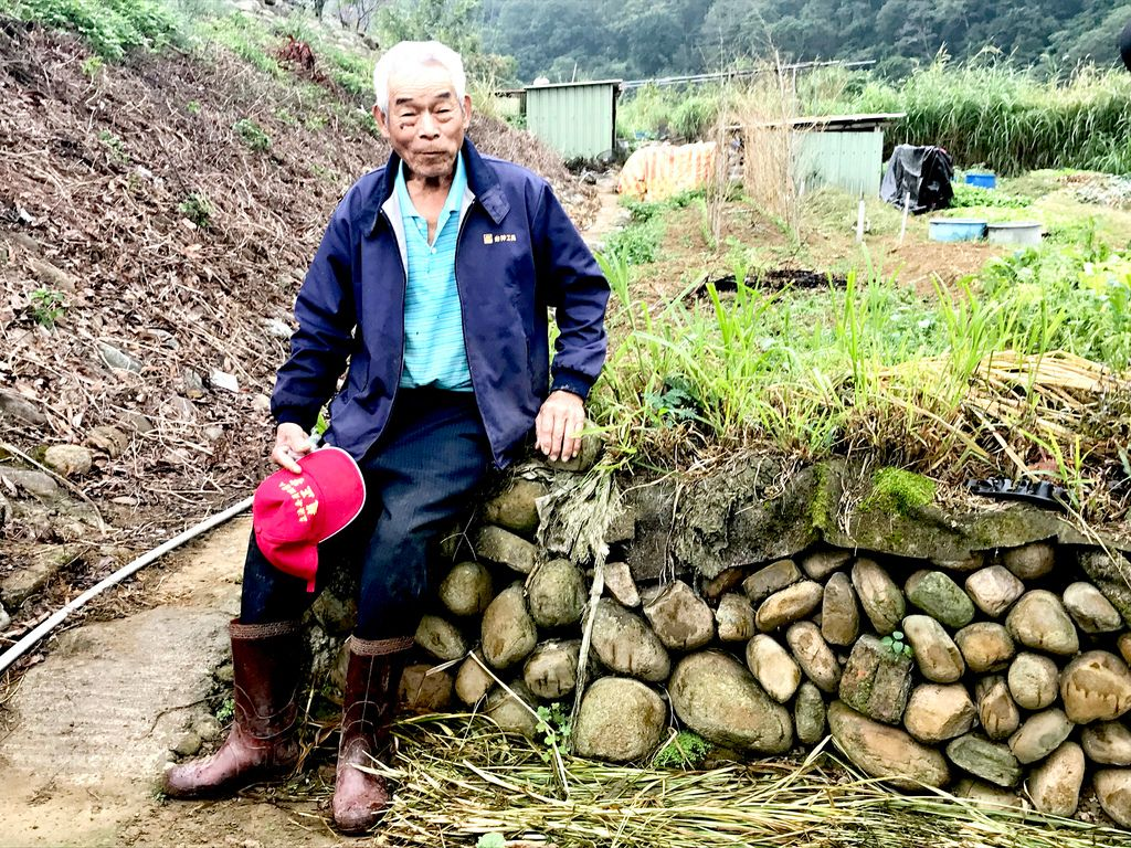 榮譽步道師羅吉榮生於新竹關西，就地以紅卵石乾砌工法，搭起永續的牆基。