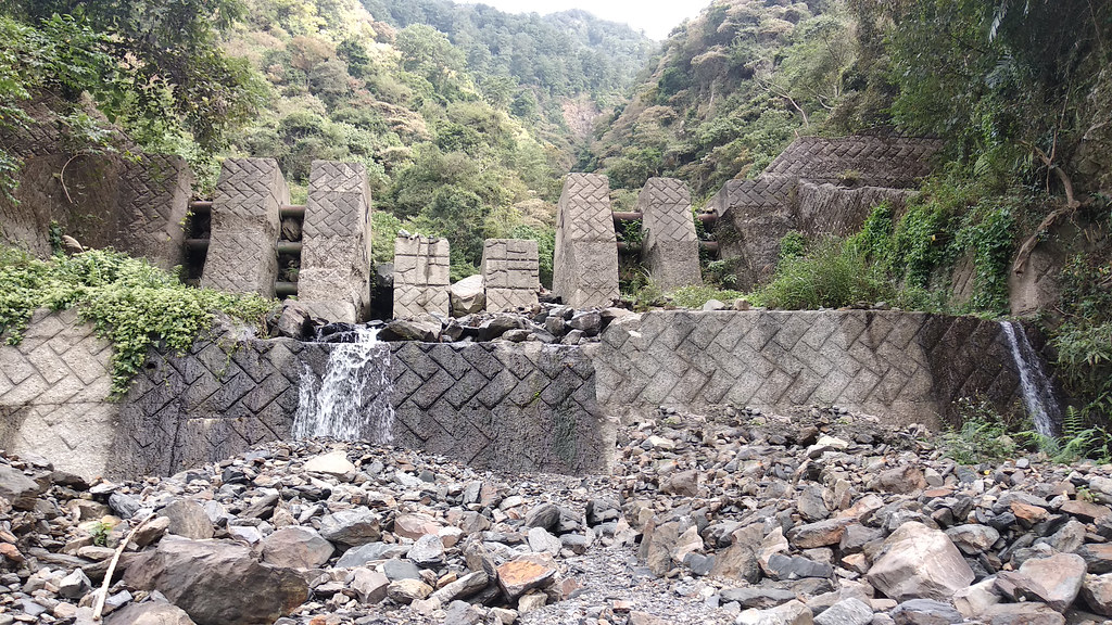 過去以混凝土壩（上圖）阻擋從上而下的土石流、漂流木，不但無法如預期完全擋住，更影響自然運作；具穿透性的鋼構壩（下圖），則與自然共處，擋住致災的量體、可拆可調，與自然和諧共存。<攝影／廖靜蕙>