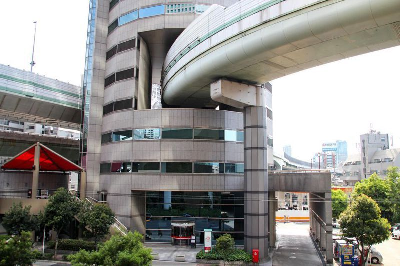 位於大阪阪神高速公路梅田出口附近的一棟圓形建築物,剛好被高速公路正面穿過,形成大阪街景中的一幅奇特畫面。這棟大樓名稱叫「門塔大廈」(TKP Gate Tower Building),是由出租會議室的大型業者TKP所管理的地上16層建築物,內有34間會議室。