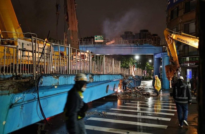 新北市養工處在拆除三重區明志陸橋時，民眾經過拍下拆除畫面。