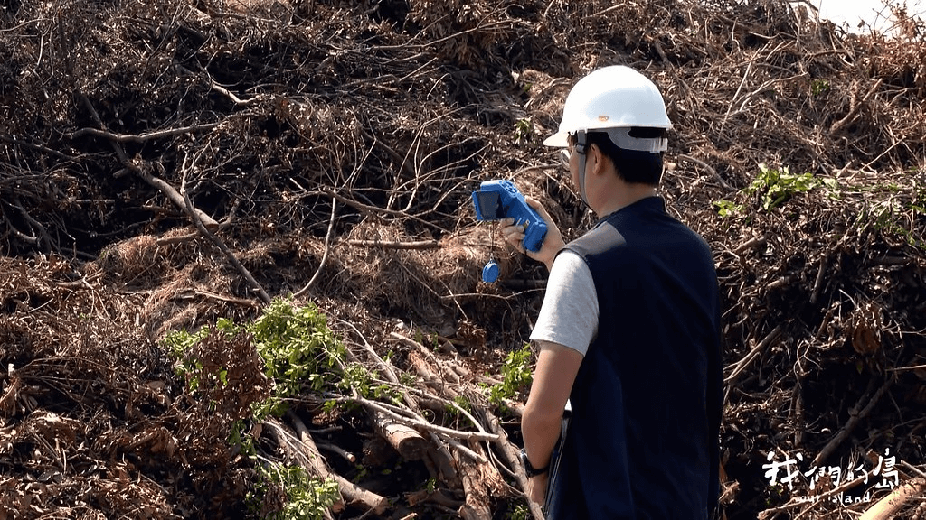 為了避免樹枝堆置溫度過高，造成悶燒，台南市環保局人員透過熱顯像儀，確認樹枝內部溫度。<圖片來源 / 公視：我們的島 >