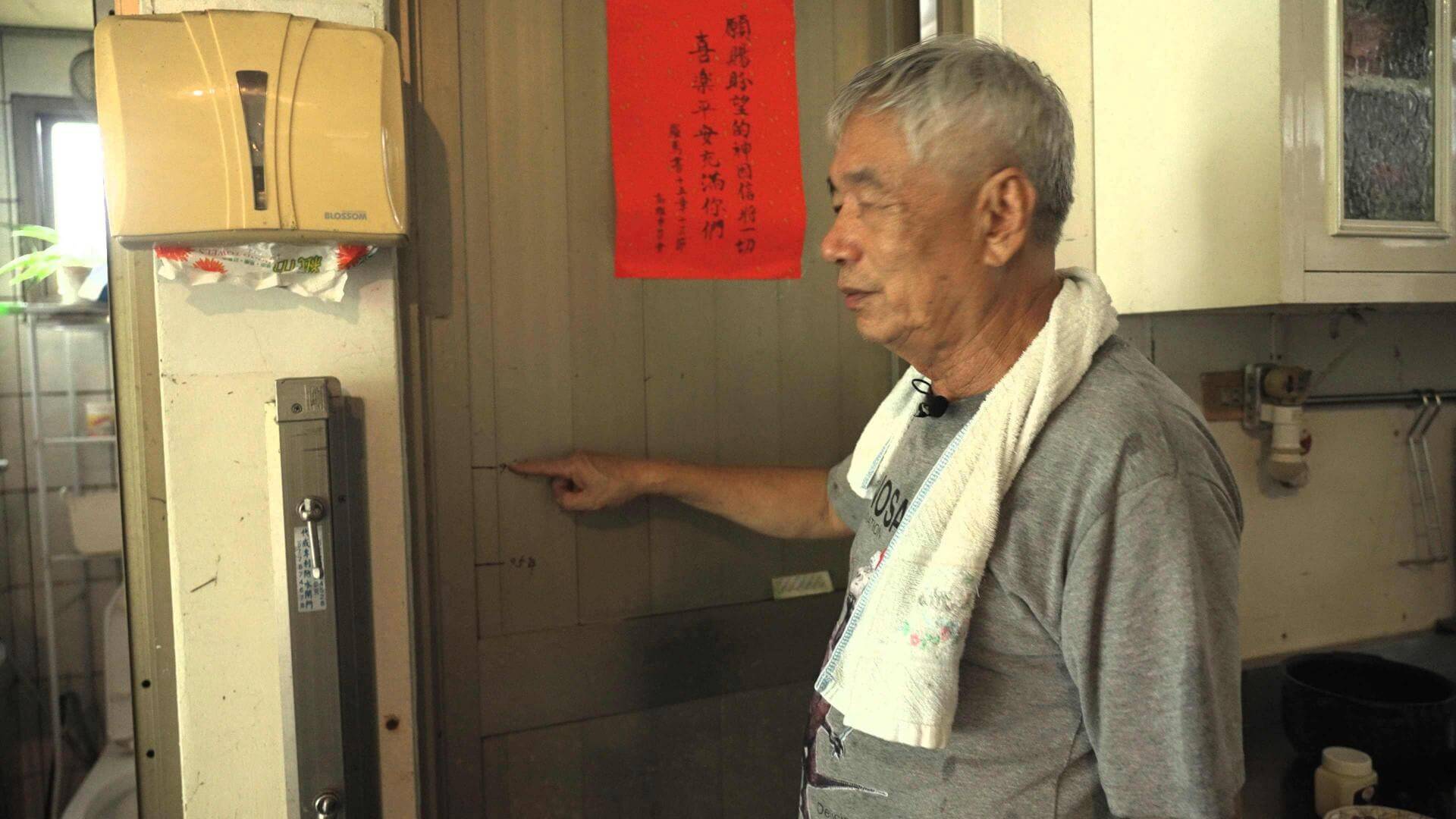 美濃居民吳先生在鋁門上記錄著每次淹水的高度。<圖 /公視 我們的島>